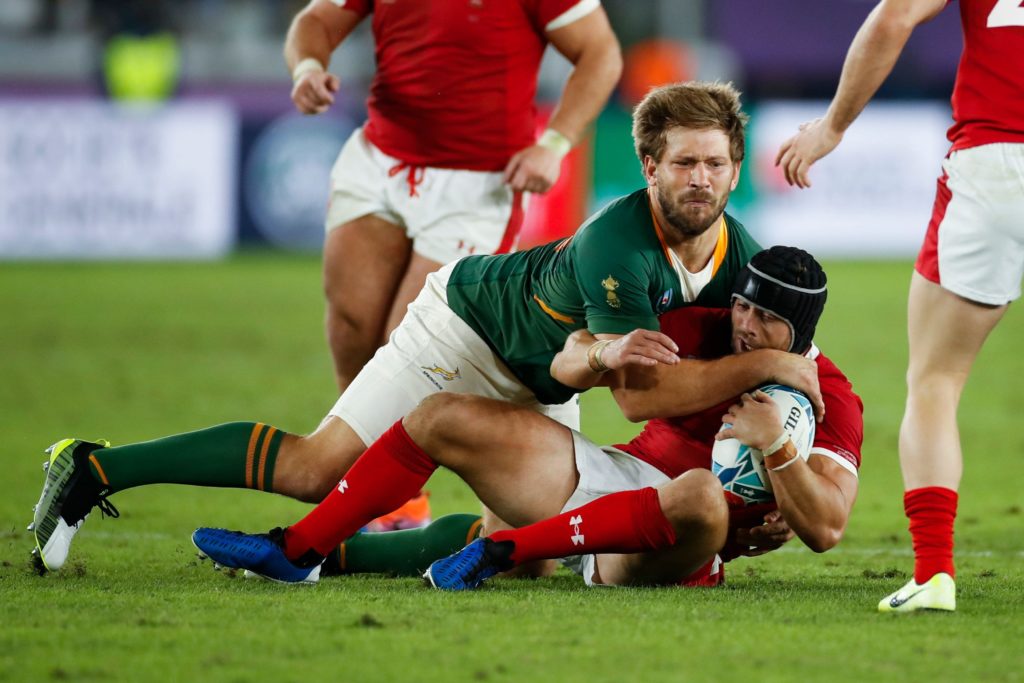 Frans Steyn of South Africa tackles Wales' Leigh Halfpenny.