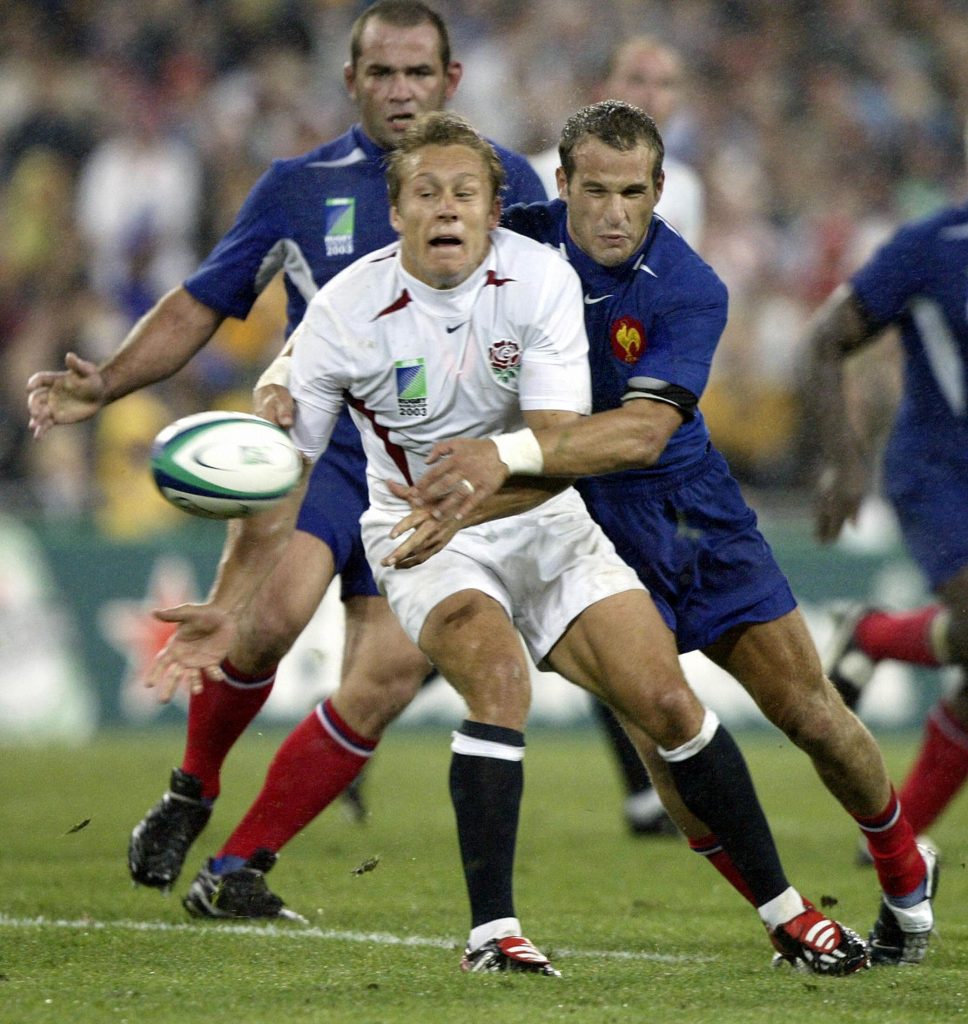 England fly-half Jonny Wilkinson passes just before being hit by France's Frederic Michalak.
